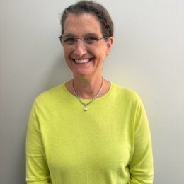 Meredith Gramlich Headshot, smiling woman wearing yellow sweater