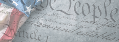 text of constitution faded on top of a U.S. flag