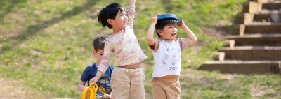 Children play in a wooden boat on the playground.