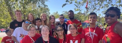 TerpsEXCEED Students at a homecoming tailgaite in red and black shirts 