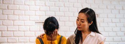 Asian mom comforts teen