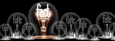 Lightbulb with fact lit up in front of lightbulbs with fake dimmed