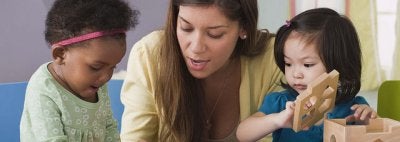 Teacher demonstrating technique to two children