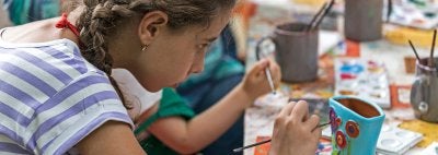 Girl paints ceramic piece
