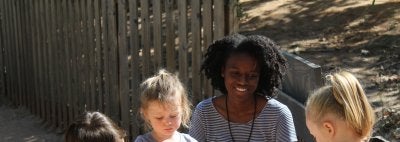 Aide with children in the sandbox