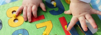 Baby places numbers in puzzle
