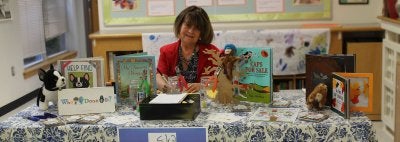 Anne Daniel sitting at Families Read display.