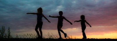 Silhouettes of children against a sky