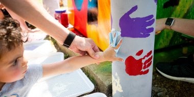 A child places a handprint on a pole as part of a community-based art project led by the Lakeland community of College Park, Clinical Associate Professor Margaret Walker, and College of Education graduate students.