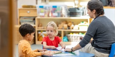 Children practice giving each other messages in the great room.