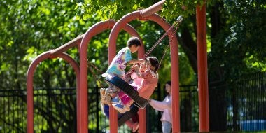 Children swing on the tire swing on the playground.