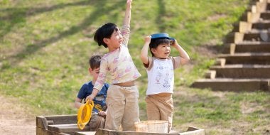 Children play in a wooden boat on the playground.