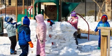 Children build an igloo on the playground. 