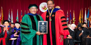 Anisha Campbell receiving a President's Distinguished Service Award at the 2026 Faculty and Staff Convocation, with President Darryll J. Pines