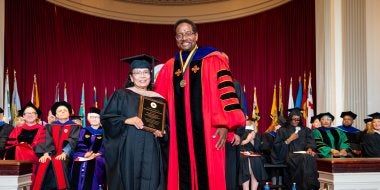 Blesilda Ladines-Lim receiving a President's Distinguished Service Award at the 2026 Faculty and Staff Convocation, with President Darryll J. Pines