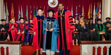 Jing Lin receiving the designation of Distinguished Scholar-Teacher at the 2026 Faculty and Staff Convocation, with Provost Jennifer King Rice and President Darryll J. Pines