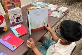 Boy Reading book at desk - Summer Reading Program