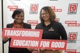 Staff members hold up a sign reading "Transforming Education for Good" on Giving Day 2026.