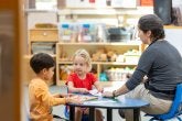 Children practice giving each other messages in the great room.