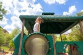 A child smiles while on the big climber on the playground. 