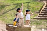 Children play in a wooden boat on the playground.