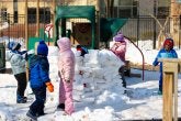 Children build an igloo on the playground. 