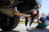 A child points to the tail pipe during a demonstration for their car study.