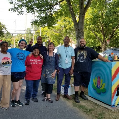 Lakeland of College Park community members, University of Maryland College of Education students and Clinical Associate Professor Margaret Walker (third from right) with their community-based art project representing Lakeland's history and culture.