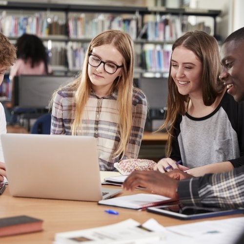 Four students studying together in a library. Photo by iStock