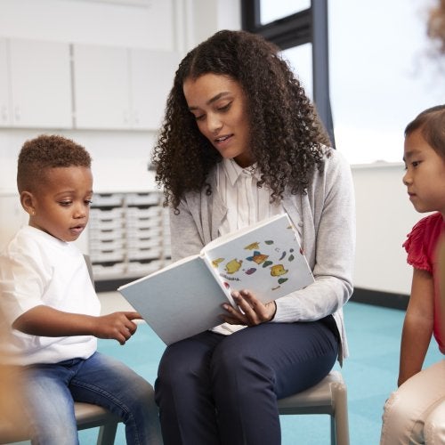 A teacher reads to children in the classroom.