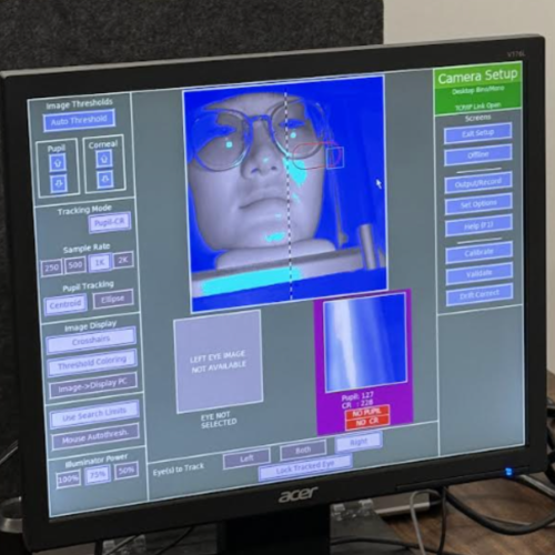 A screen used in eye tracking research shows a person's face as they read and listen to text