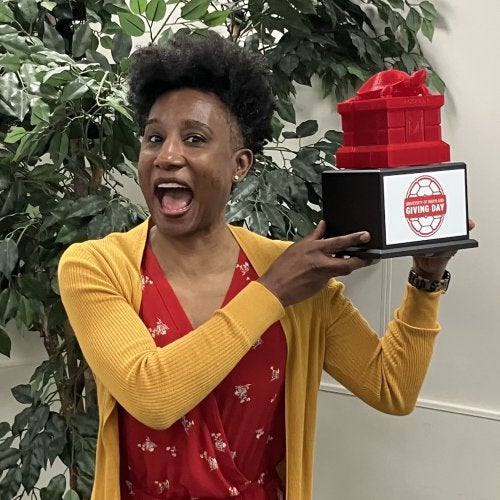 Dean Kimberly Griffin shows off the Testudo trophy, which the College of Education received for the fifth consecutive year in 2026 for winning the faculty/staff power hour on Giving Day.
