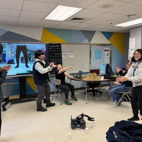 Students at A. Mario Loiederman Middle School cheer as they test the robot they built at the UMD-MCPS afterschool program Co-Learn Code and Mind.