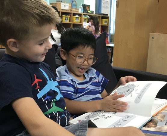 Two children looking at a book