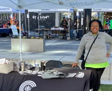 Woman standing near a table at an event promoting her business