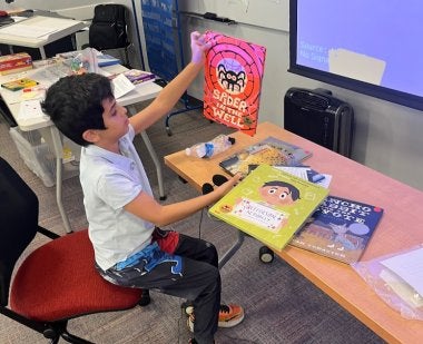 A child holds a book at the 2025 Summer Reading Program.