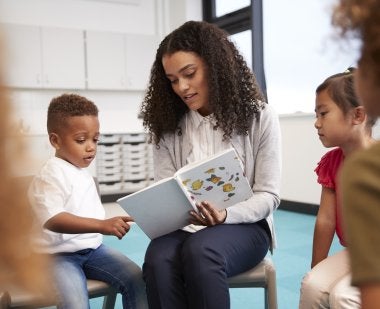 A teacher reads to children in the classroom.