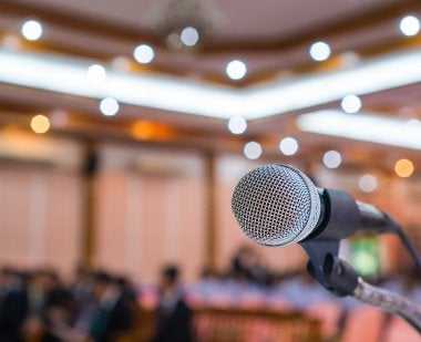 Microphone in foreground of a conference hall