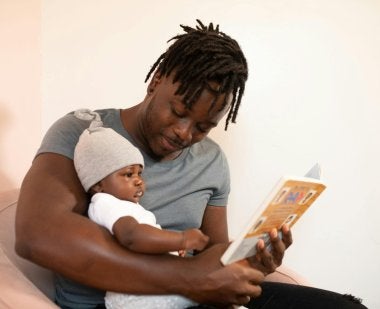 A dad reads to his baby.