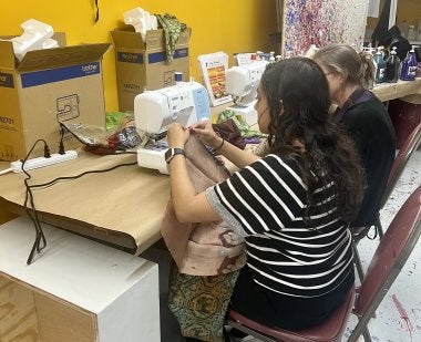 Margaret Walker, assistant clinical professor, and a student work together to sew assorted fabrics that will become part of a community-based art project at Maryland Day.