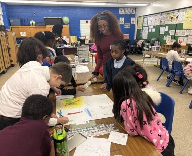 A teacher and a group of third graders at Brandywine Elementary School create posters as part of the Bullying Literature Project.