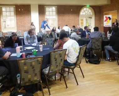 Participants at “Who Has the Power? The Constitution and Our Role in Securing Democracy" engage in small group discussion at tables in the Stamp Student Union.