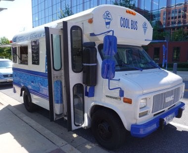 Carol Pisciotta '96 runs her ice cream and shaved ice business out of a school bus converted into an ice cream truck. The bus is painted blue and white, with the words "COOL BUS" on the front.