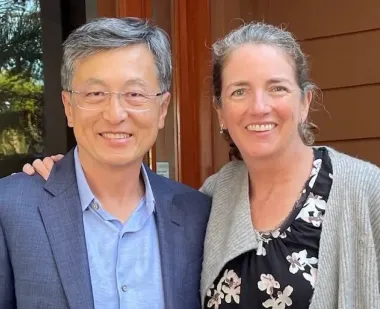 MILE donors Ho Nam and MR Macgill stand next to each other, with Macgill's hand on Nam's shoulder.