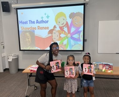 Students hold book during Summer Reading Program
