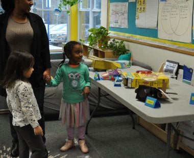 child showing parent her airplane made of recycled materials