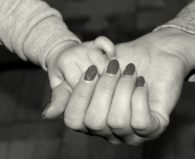 Adult and Child Hold Each Others' Hands