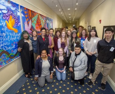 BSU and UMD faculty and staff pose in front of Unity Mural