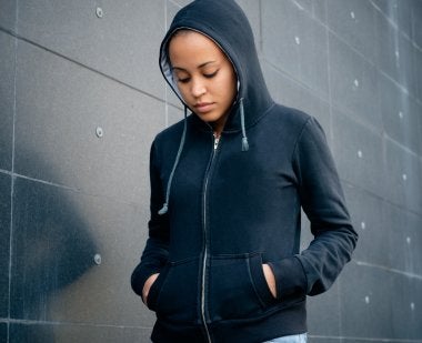 Young woman in hoodie looking down