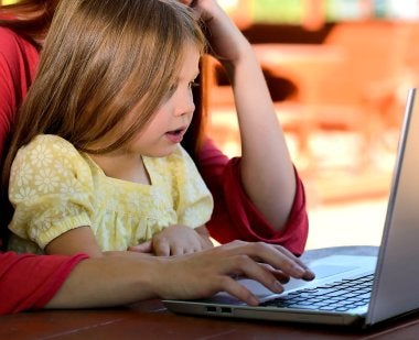 Image of child and parent on laptop